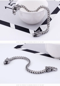 Detailed view of heavy stainless steel bracelet with dual wolf heads and wheat chain link