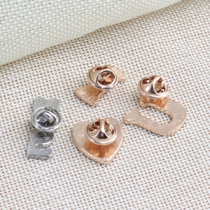 Back view of ILOVEU heart alloy pins with butterfly clasps on woven fabric