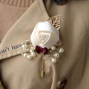 Ivory rose boutonniere with burgundy ribbon and gold leaf pin for wedding suits