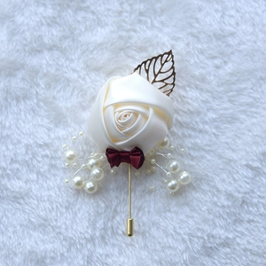 Detail of handmade ivory ribbon rose boutonniere with gold leaf and pearl accents