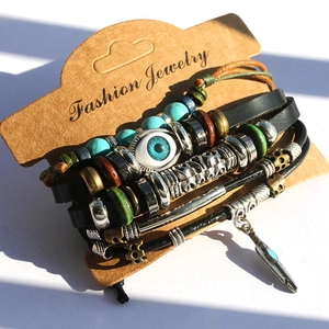 Detail of layered leather bracelet with turquoise evil eye bead and feather charm