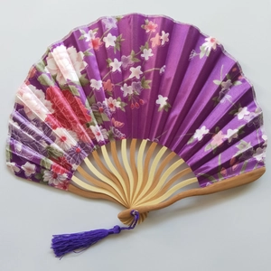 Detail of a purple Japanese silk folding fan with floral patterns and bamboo ribs