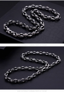 Macro view of industrial silver metal necklace with grooved oval links and retro texture