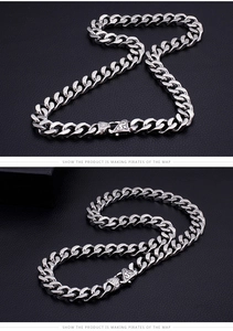 Detail of silver titanium steel Cuban chain necklace with pirate pattern triangle clasp