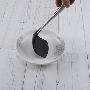 Black silicone turner with 304 stainless steel hollow handle shown on a white tabletop