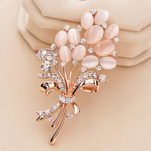Close-up of elegant flower brooch with pink cat eye stones and sparkling crystals