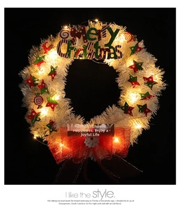 Detailed close-up of a white Christmas wreath with festive LED lights and star ornaments