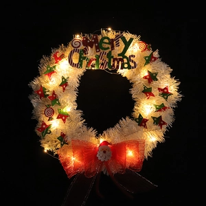 Lighted Christmas wreath with white mesh stars and warm LED lights on black background