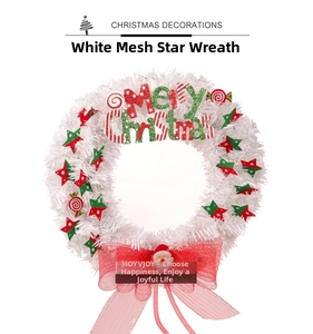 Detail of white Christmas wreath featuring stars, candies, and a Santa Claus motif