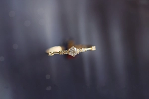 Macro shot of polished 14K gold plated ring with seven small diamonds on band