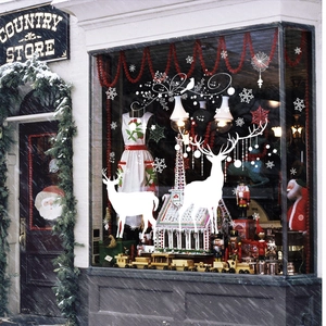 White Christmas reindeer and snowflake window decals on a festive store glass display