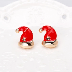 Macro view of Christmas Santa hat stud earrings with red enamel and gold stars