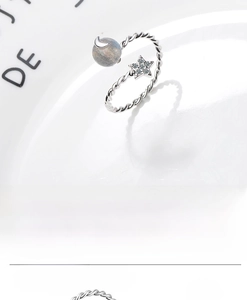 Close-up of star and moon open ring with twisted band and grey moonstone inlay