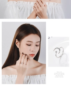 Detail of adjustable silver ring featuring moon and star motifs with small crystal accents