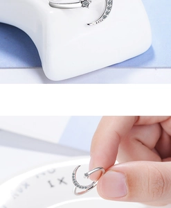 Detail of silver moon and star open ring with sparkling crystal inlay on model