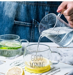 Vue détaillée d'un verre doseur résistant à la chaleur versant de l'eau dans une tasse