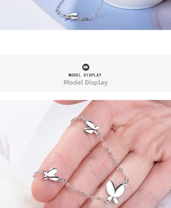 Detail of silver butterfly bracelet with sparkling zircon charms and polished finish