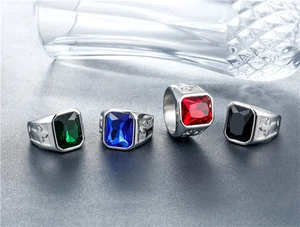 Detail of punk titanium steel rings featuring cross relief and colorful gemstones