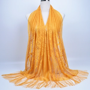 Detailed view of yellow floral lace shawl with delicate fringed edges on a mannequin