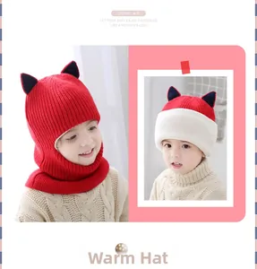 Detailed view of red knitted baby balaclava with black cat ears and warm fleece lining