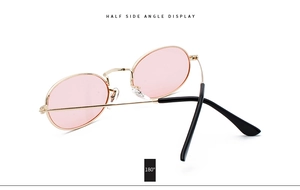 Side view of retro oval pink lens sunglasses with gold metal frame and flexible hinges