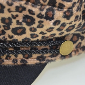 Detail der Leoparden-Militärkappe mit schwarzer Kordel und goldenem Metallknopf
