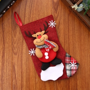 Detail of red burlap Christmas stocking with 3D reindeer doll and snowflake pattern decor