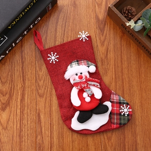 Detailed view of burlap Christmas stocking featuring a 3D snowman doll on wooden background