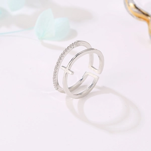 Detail of silver double-layered ring featuring a cross charm and micro-pave zircons