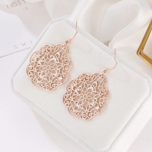 Elegant rose gold cutout earrings with vintage palace lattice pattern on a jewelry box