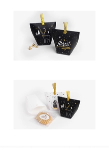 Detail of Christmas pillow boxes in black and white with gold ribbons and Merry Christmas text