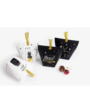 Detail of Christmas candy boxes with gold ribbons, Merci text and festive drawings