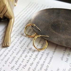 Detailed view of polished gold hoop earrings on a high-end fashion magazine background