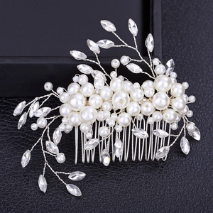Elegant bridal hair comb with pearls and rhinestones on black leather surface