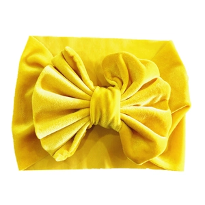 Elastic yellow velvet baby headband featuring a large bow for toddlers and infants