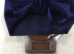 Detail shot of navy blue velvet bow headband weighing 36.8g on a digital kitchen scale