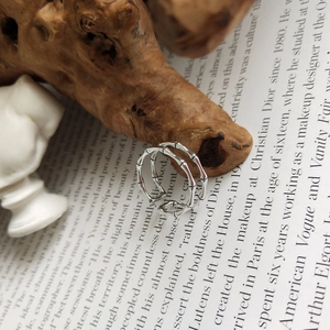 Detailed close-up of double-layer bamboo joint silver ring on a vintage book