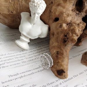Macro shot of 925 sterling silver ring with textured bamboo design on wooden block