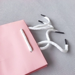 Pink paper gift bag with white woven handles and high-quality textured finish
