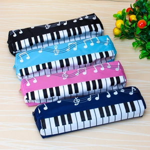 Piano keys and musical notes pattern cylinder pencil cases in four colors on desk