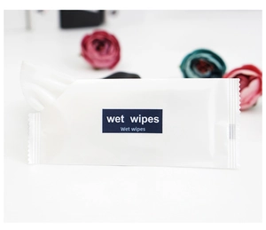 Close-up of individually wrapped wet wipes in white packaging with floral background