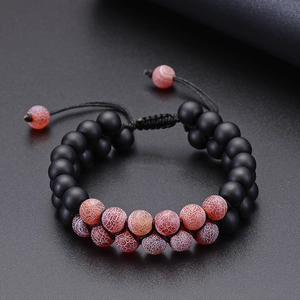 Macro view of double-layer beaded bracelet with matte black and orange cracked natural stones