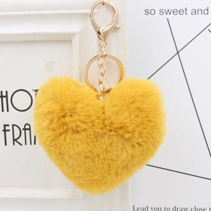Close-up of fluffy yellow heart plush keychain with golden metal clasp and chain