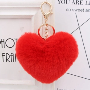 Close-up of fluffy red heart plush keychain with golden metal ring and lobster clasp
