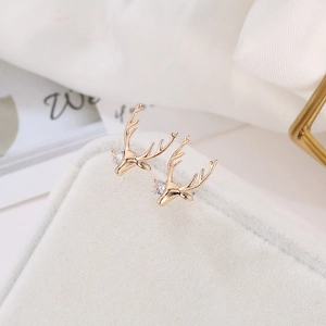 Boucles d'oreilles cerf en or rose avec zircons scintillants sur présentoir en velours