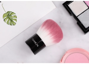 Vue détaillée des poils denses en dégradé rose d'un pinceau kabuki professionnel à poudre