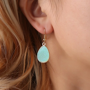 Elegant gold drop earrings with mint green druzy texture shown on model for women