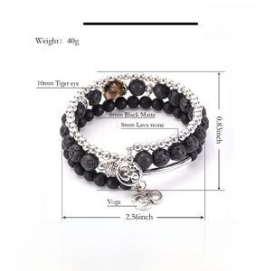 Detailed view of multilayer yoga bracelet with tiger eye, lava stone and Om charm