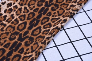 Close-up detail of leopard print fabric with sharp texture and classic brown pattern