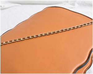 Close-up of caramel pumpkin chain bag featuring scalloped edges and gold link strap